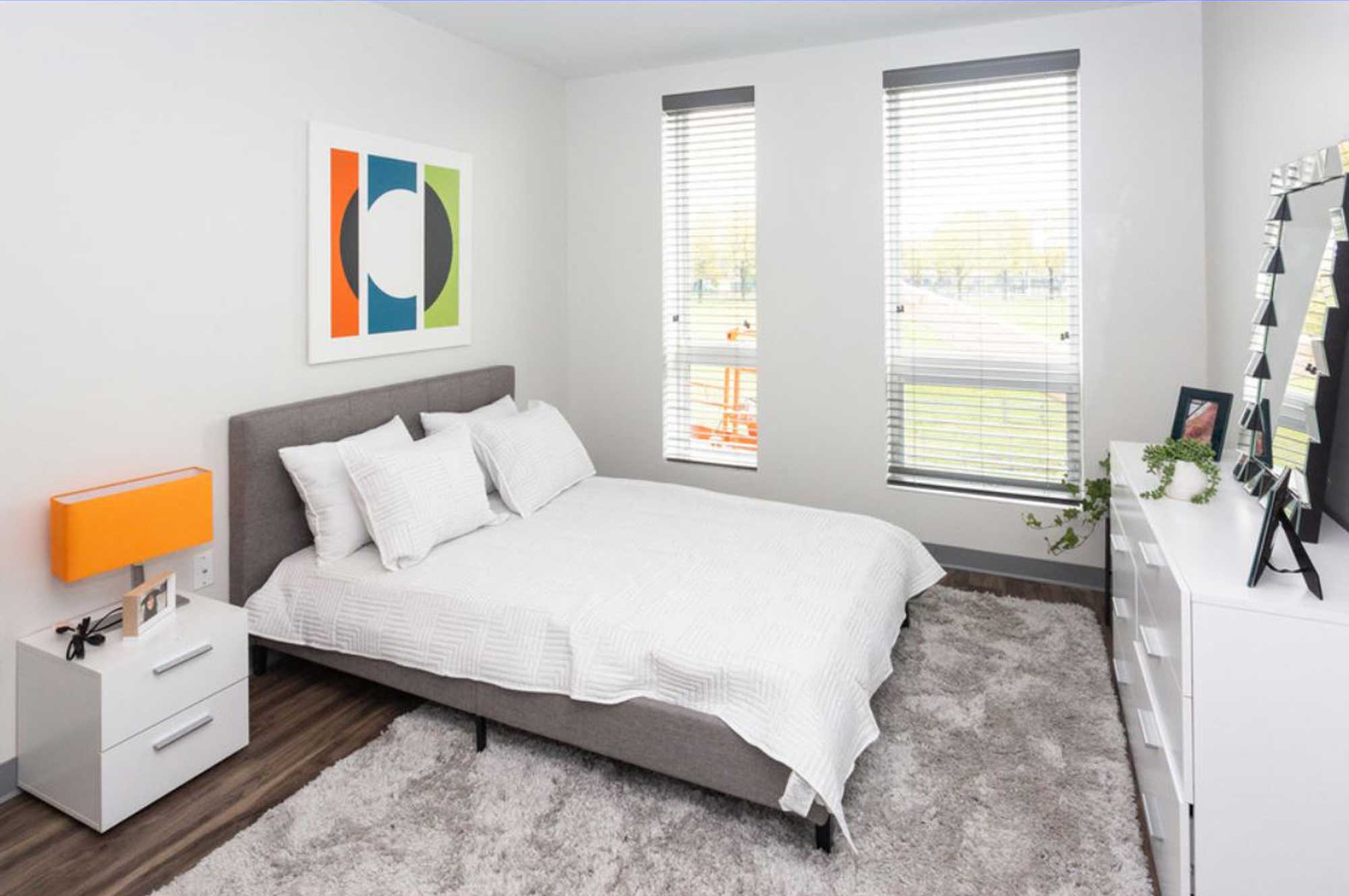 Two tall windows, carpet flooring, modern interior design.