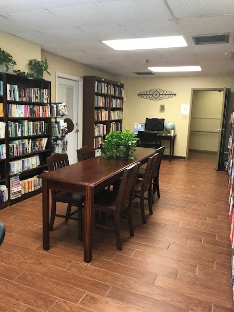 large reading room with books, large table, and computer