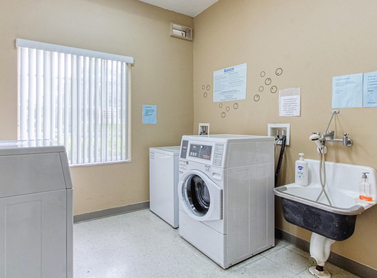 Laundry room with washers, dryers, and laundry sink