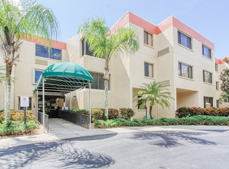 Villa San Carlos Senior Apartments with palm trees and covered entrance
