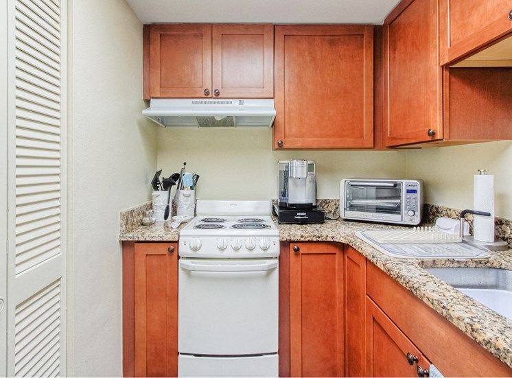 kitchen with pantry, appliances, stainless steel sink, and granite countertops