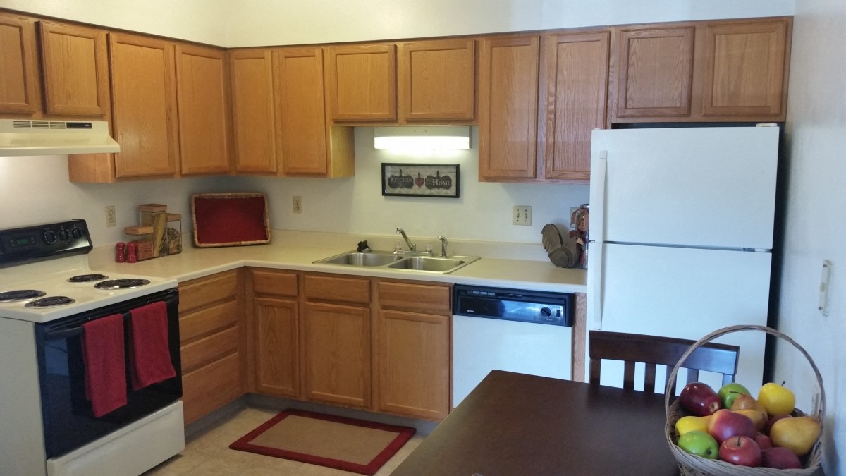 Seville Kitchen 1 Kitchen with electric range, dishwasher, and refrigerator at Seville Apartments in Iowa City, IA