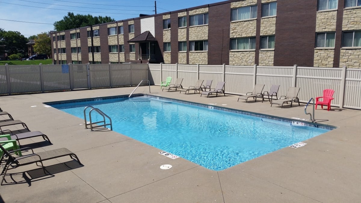 Swimming pool with furniture at Seville Apartments in Iowa City, IA
