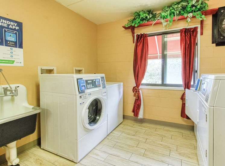 community laundry room with washers, dryers, and laundry sink
