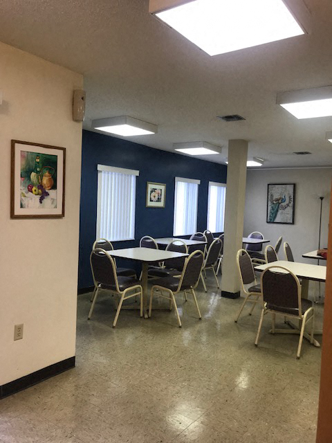 community room with tables and chairs by large windows