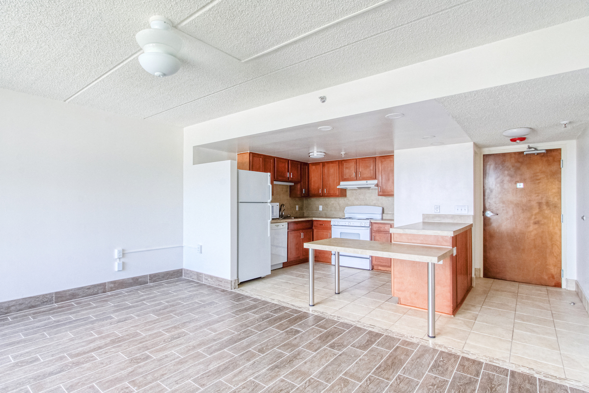 kitchen with efficient appliances, hardwood-style flooring, and island