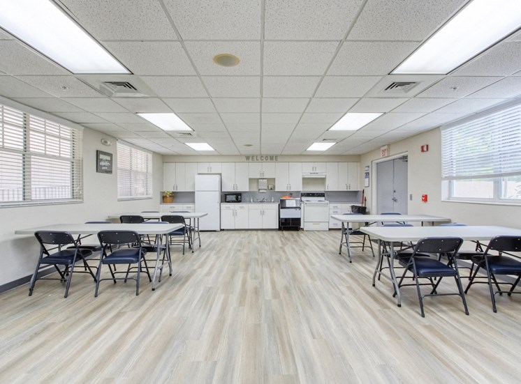community room with kitchen and tables and chairs for residents