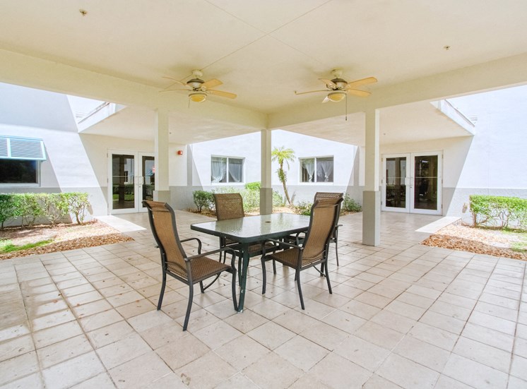 covered patio with ceiling fans and table and chairs