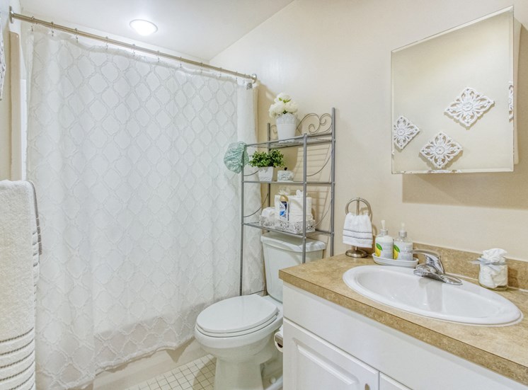 bathroom with large vanity, toilet, and shower-tub