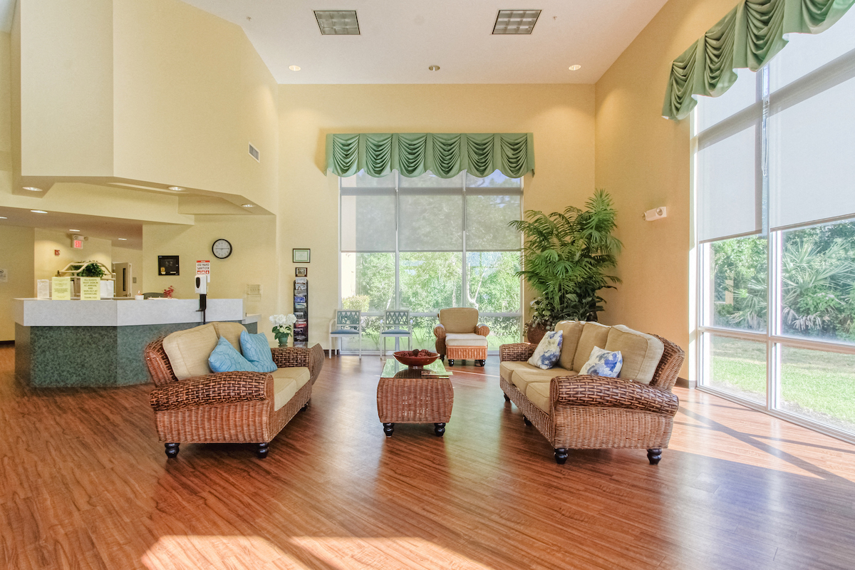 comfortable couches and chairs and reception desk in lobby by large windows