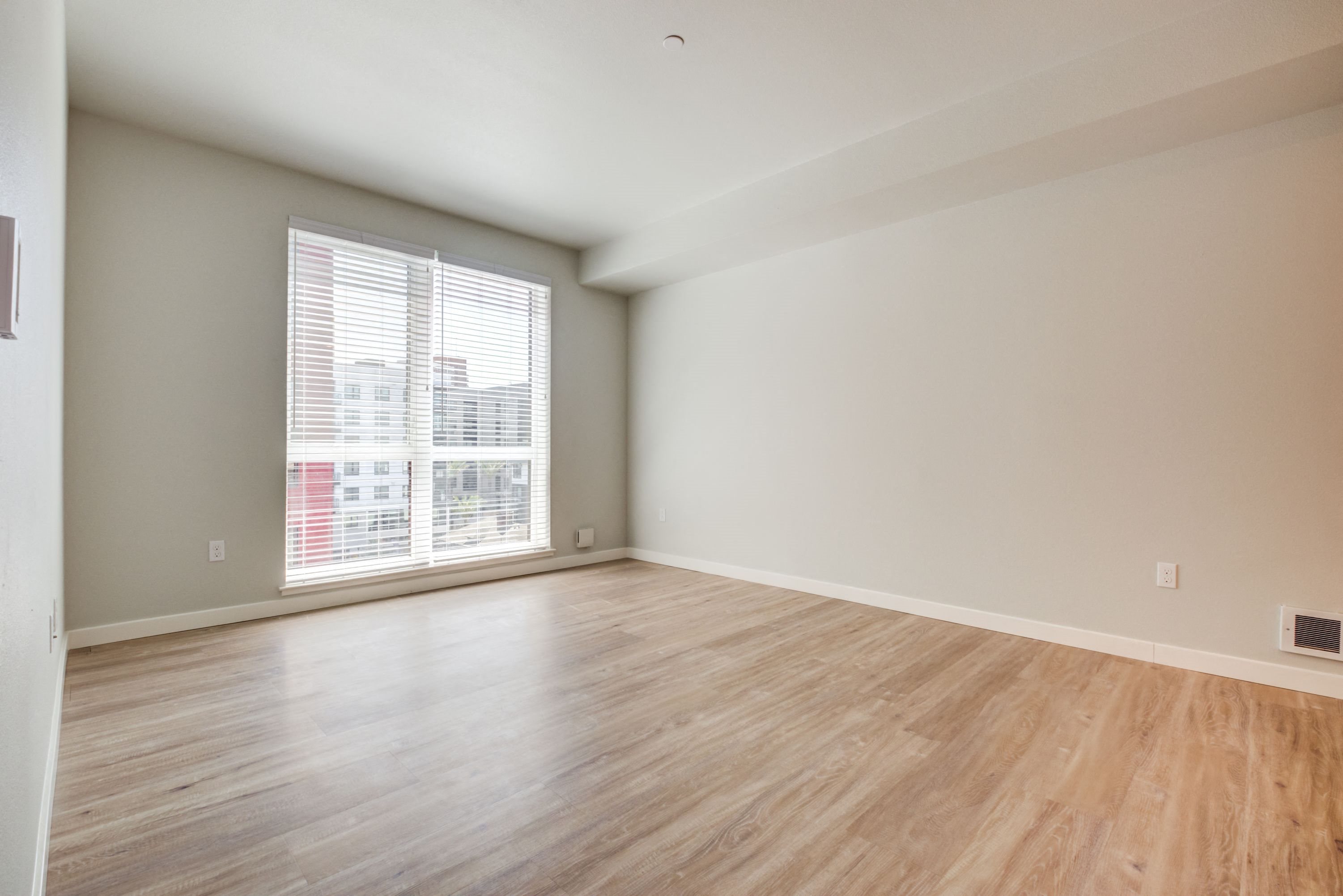 Large room with wood floors and patio window