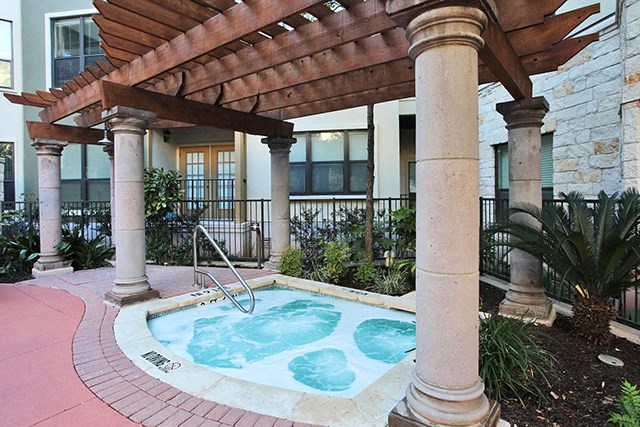 Heated spa under gazebo inside pool courtyard