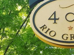 Street side monument sign near tree lined sidewalk