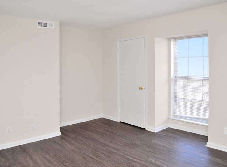 large window and plank flooring in apartment bedroom