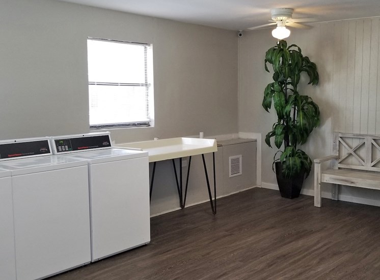 Laundry room with folding table and bench at River Road Terrace