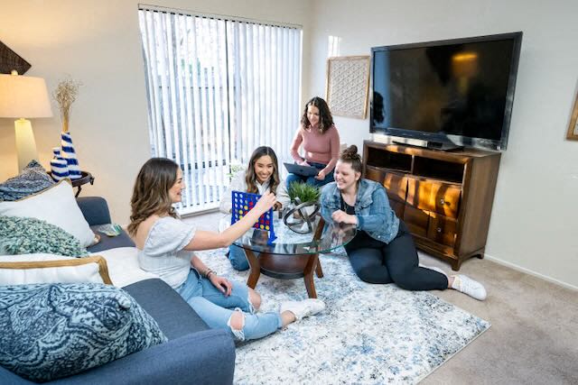 Residents play a game in a living room at Casitas
