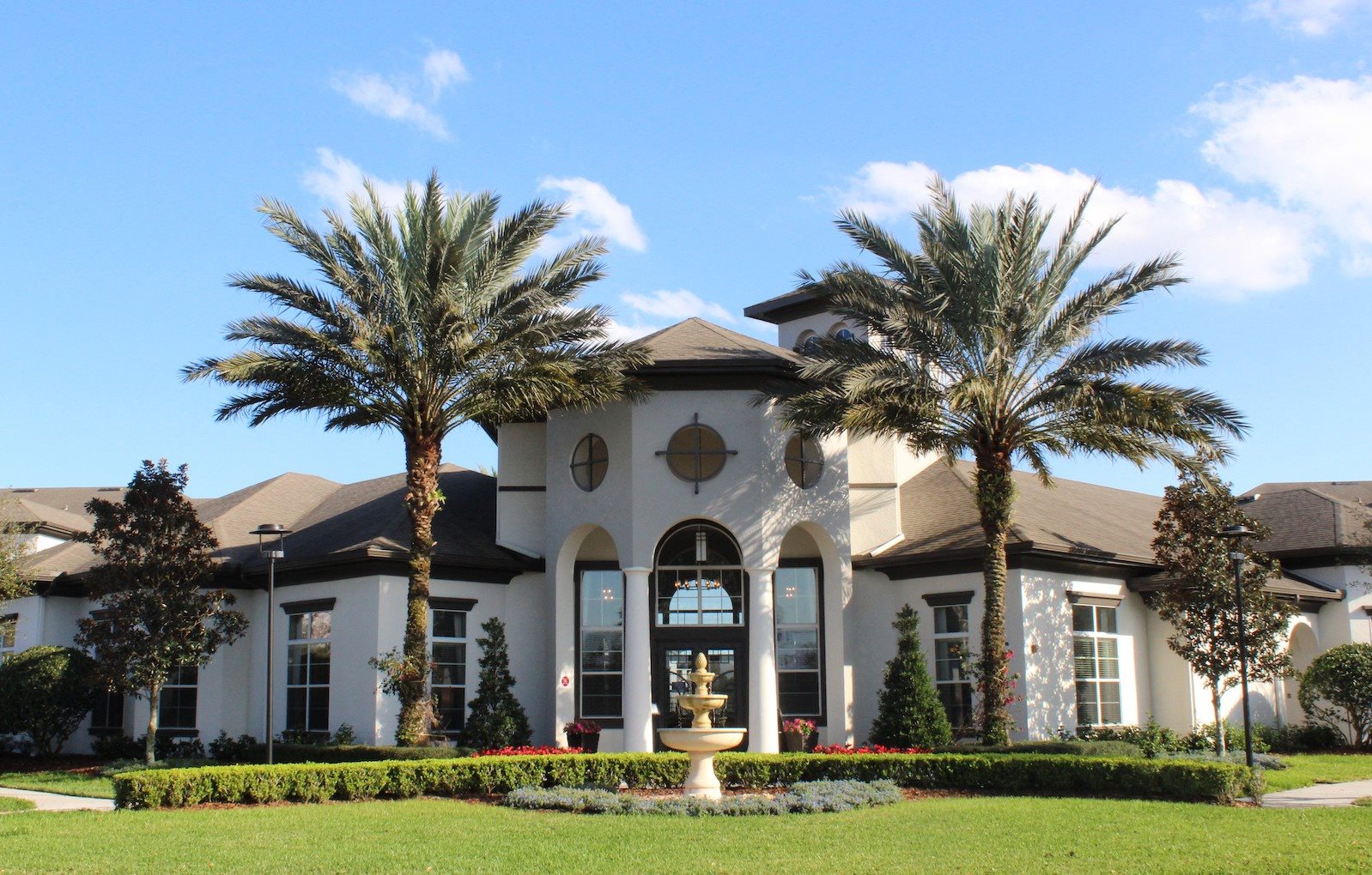 Water Mark Clubhouse with towering Palm Trees and fountain