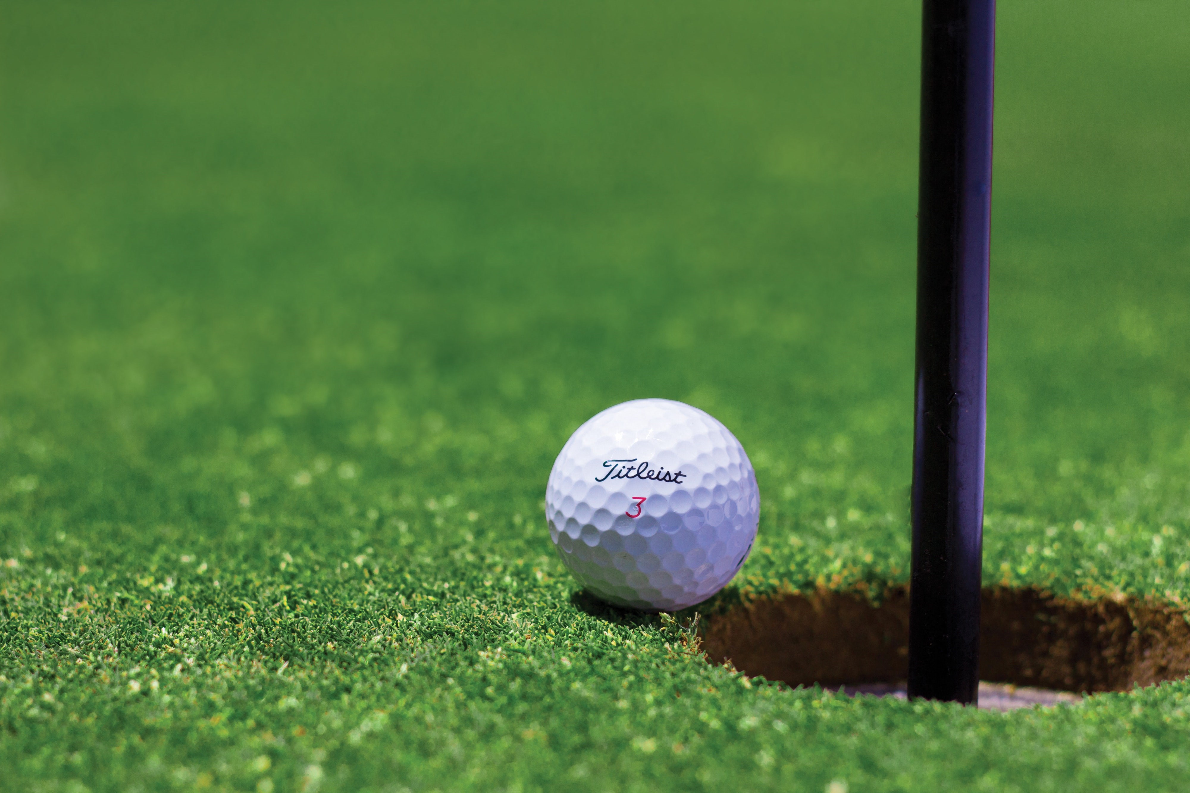 Golf ball next to a hole on golf course, Wendover Nevada