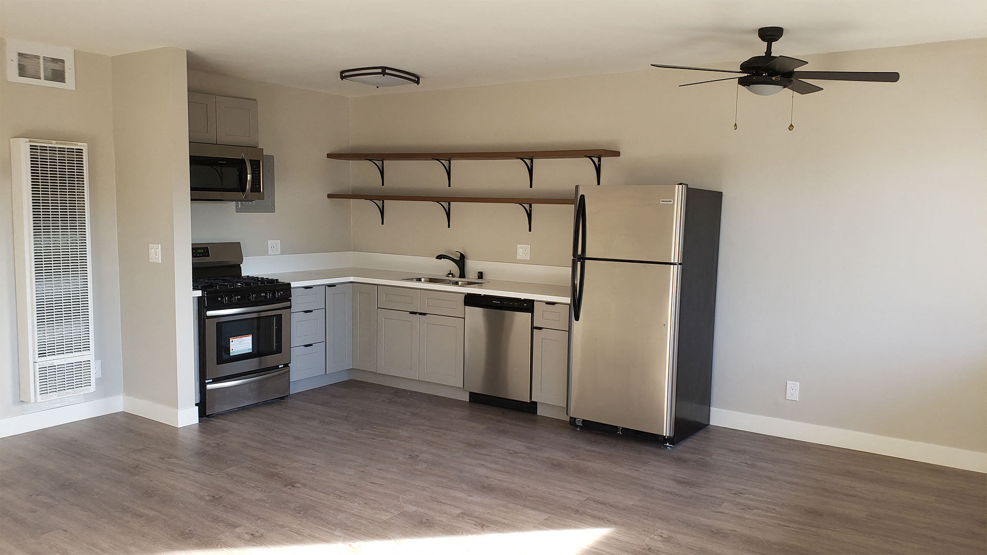 Kitchen Area with Shelf Units, White Countertops, Stainless Steel Appliances, Hardwood Flooring at Wilson Apartments