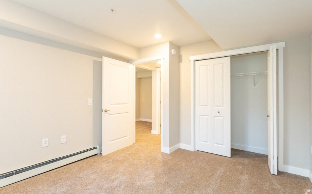 A room with white walls and carpeted floor.