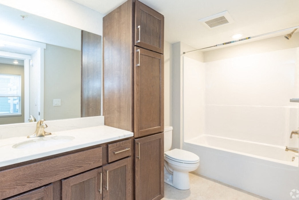 A white sink is on a countertop in a bathroom.