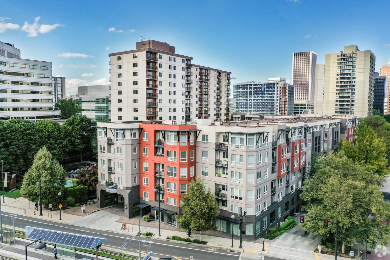 Apartments for Rent in Downtown Portland, OR - Linc 301 - Aerial View of Property with Red, White, and Grey Building Exterior, and Surrounding Cityscape Views.