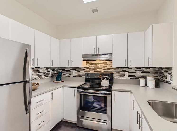 Apartments for Rent in Downtown Portland OR - Linc 245 - White Kitchen with Stainless Steel Appliances and a Tiled Backsplash