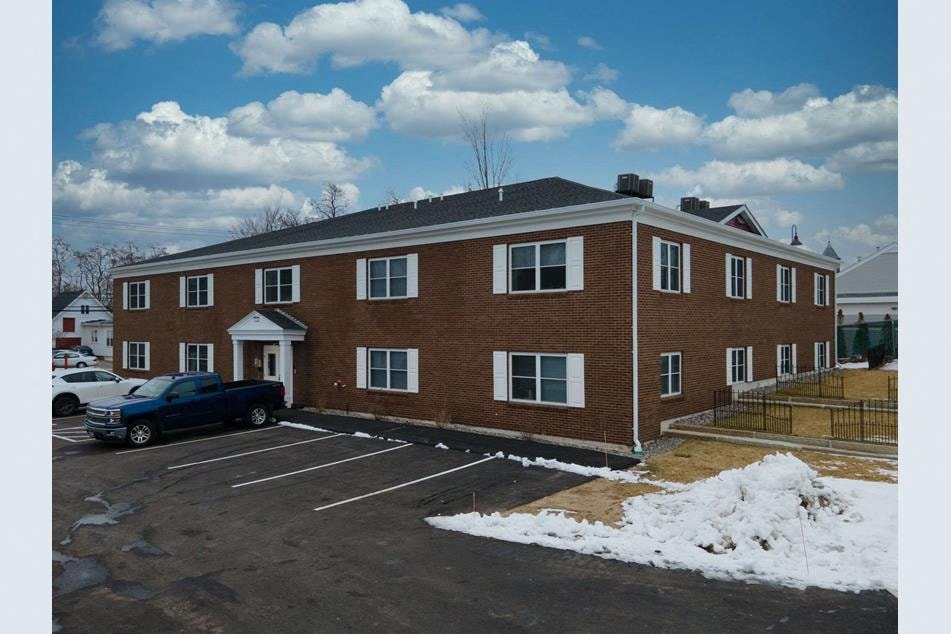 a large brick building with a parking lot and snow
