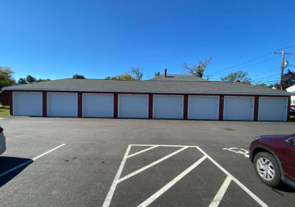 an empty parking lot in front of a building with a roof