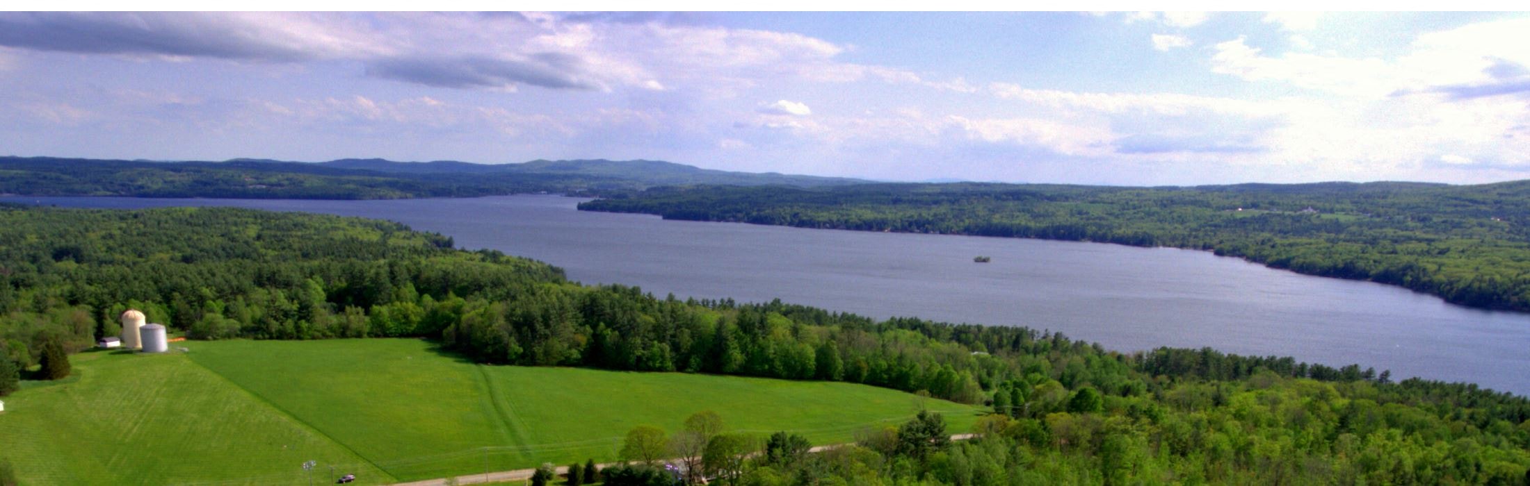 a view of a lake from above with a church on a hill