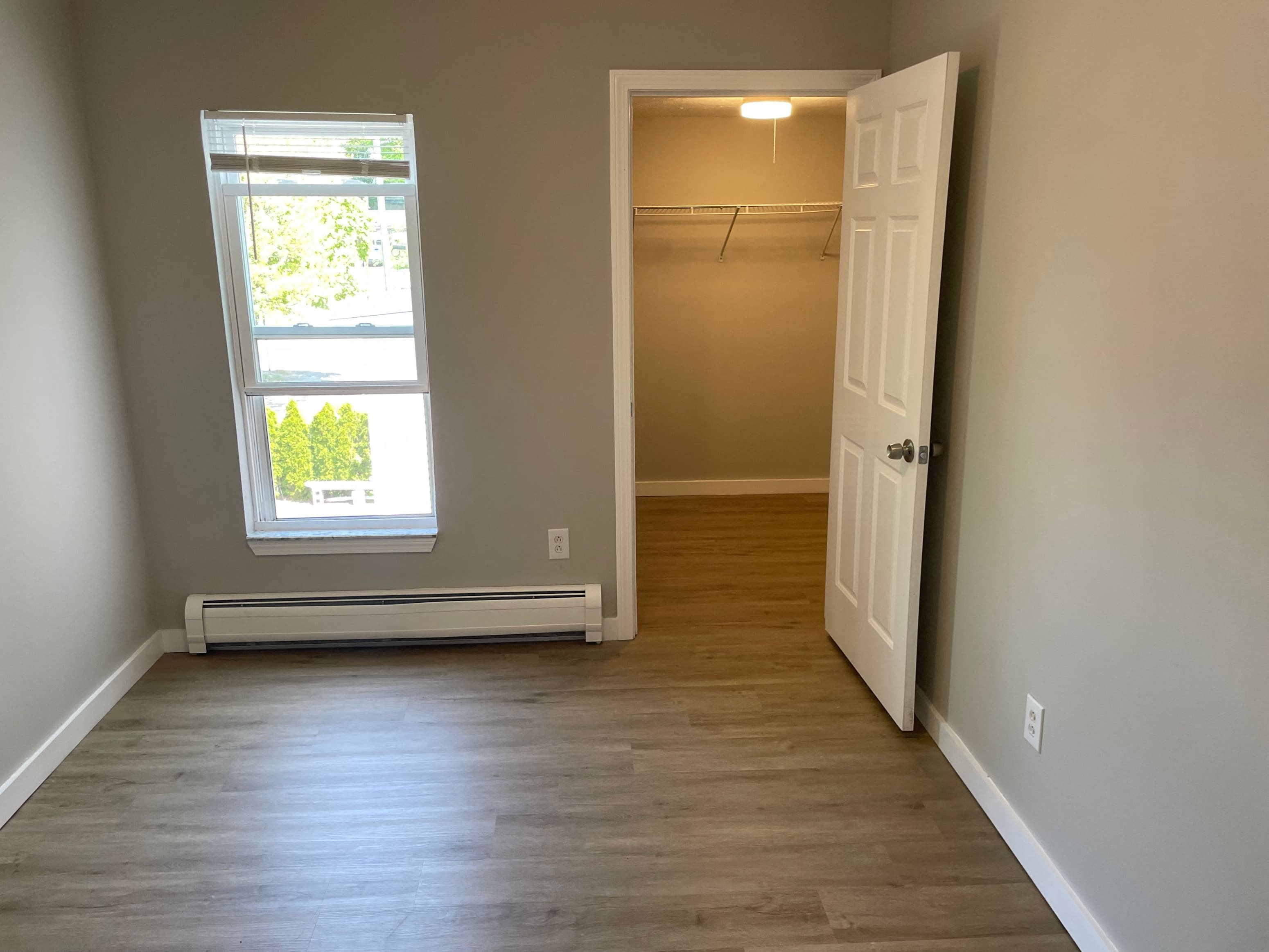 an empty room with a closet and a window