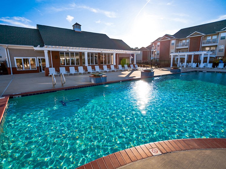 sun setting over the pool behide the clubhouse at 1200 Acqua Apartment homes near Fort Lee Virginia