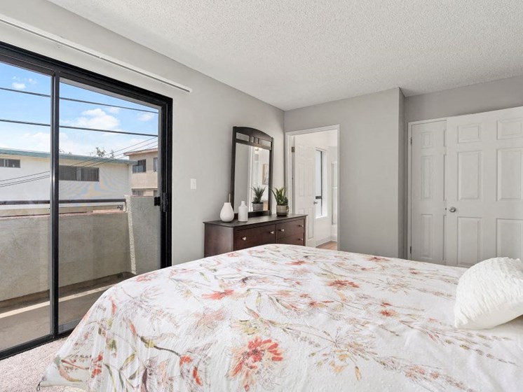 Apartments in North Hollywood, CA - Spacious Bedroom with Berber Carpet and Sliding Glass Doors to Patio.