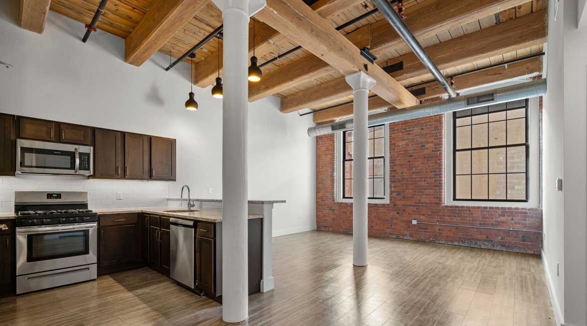 Open floor plan, exposed beams and brck