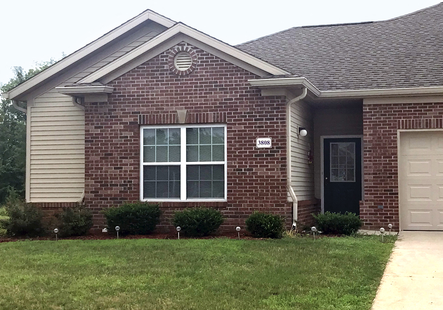Exterior of Village at Wayne Trace, Brick apartment home, two attached garages, green landscaping