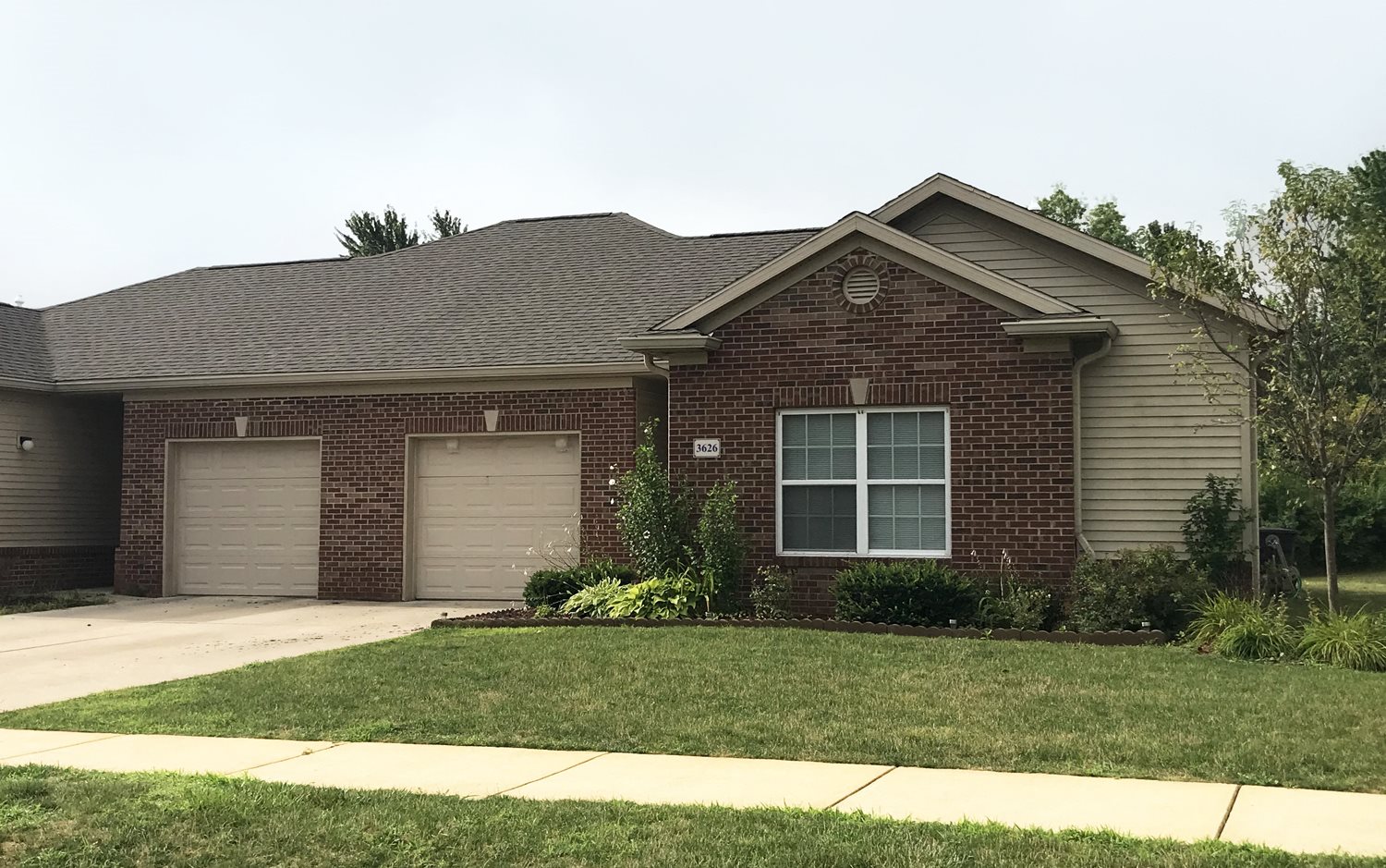 Exterior of Village at Wayne Trace, Brick apartment home, two attached garages, green landscaping