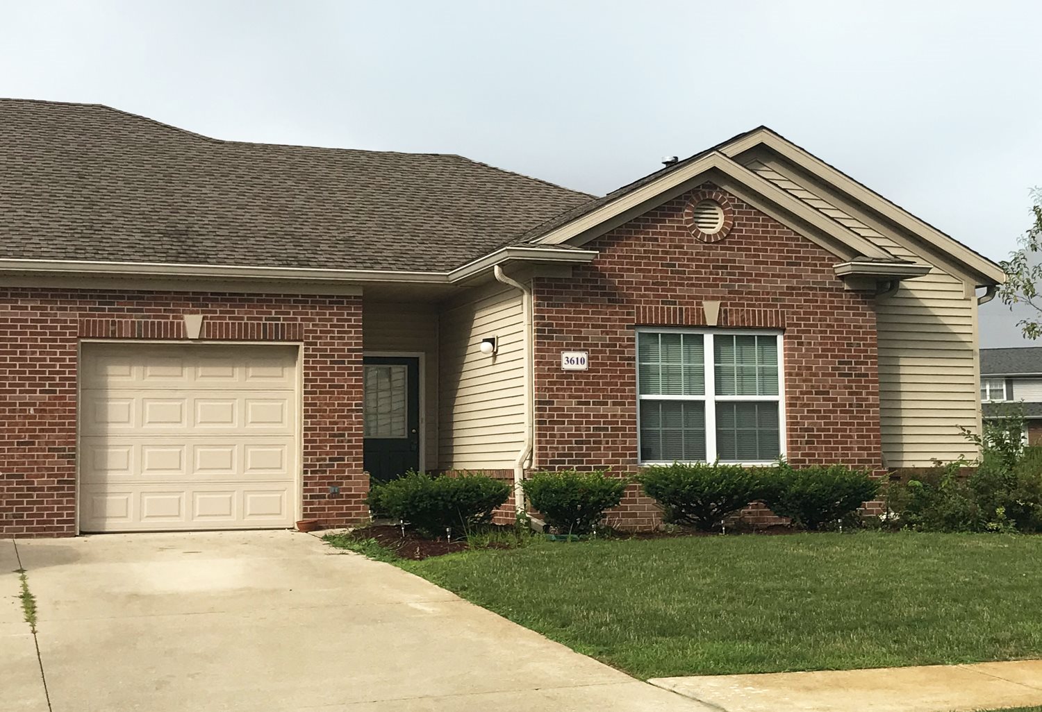 Exterior of Village at Wayne Trace, Brick apartment home, two attached garages, green landscaping