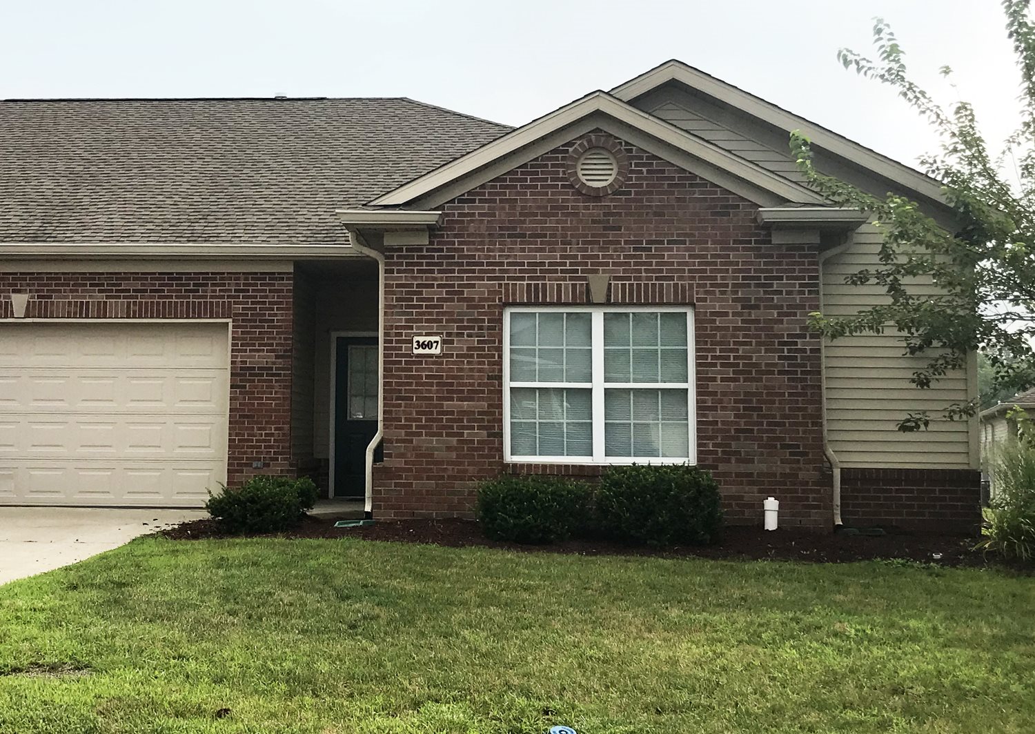 Exterior of Village at Wayne Trace, Brick apartment home, two attached garages, green landscaping