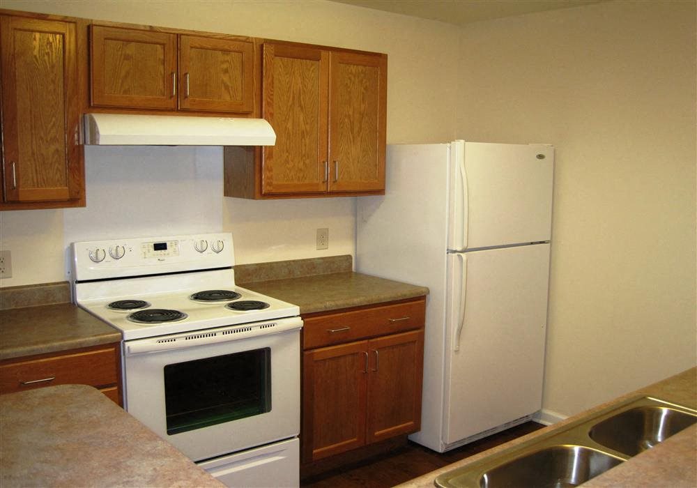 Kitchen, wood floors, wooden cabinets, extended sink and pantry, white appliances