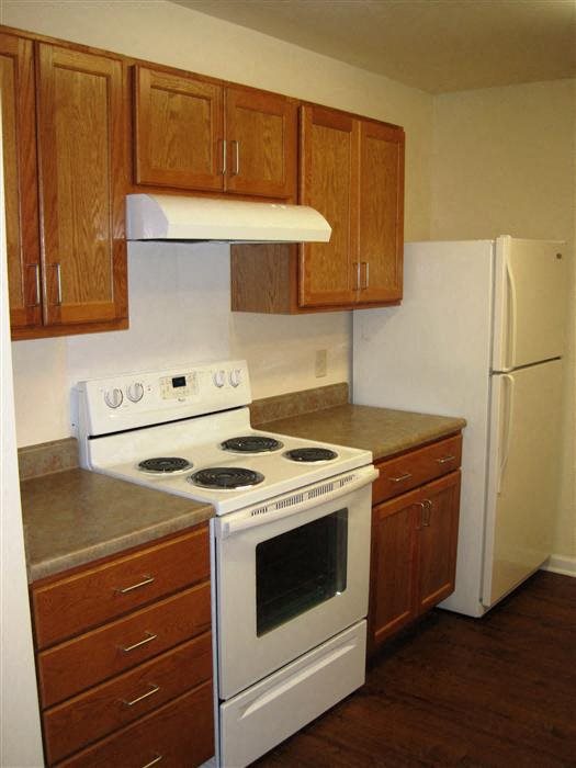Kitchen, wood floors, wooden cabinets, extended sink and pantry, white appliances