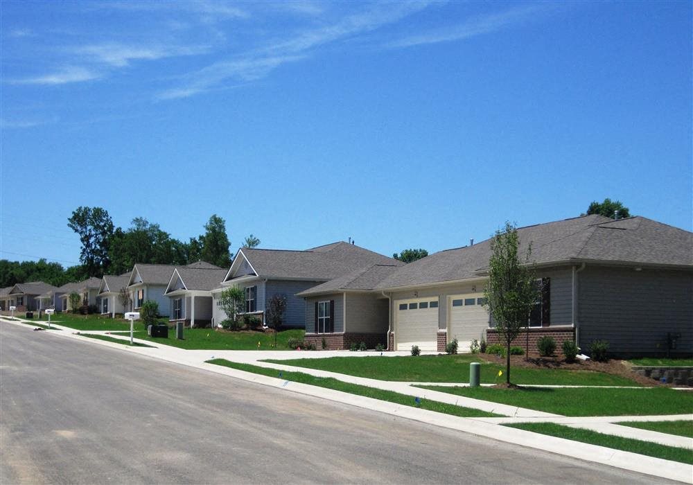 Exterior of Apartment homes, brick homes, two garage doors, green landscaping