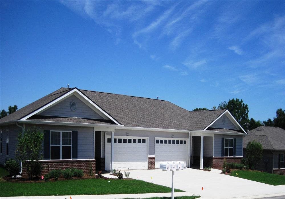 Exterior of Apartment home, brick and blue colored home with manicured green landscaping