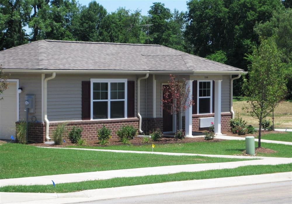 Exterior of Apartment home, brick and blue colored home with manicured green landscaping