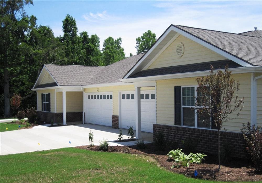 Exterior of Apartment home, brick and blue colored home with manicured green landscaping
