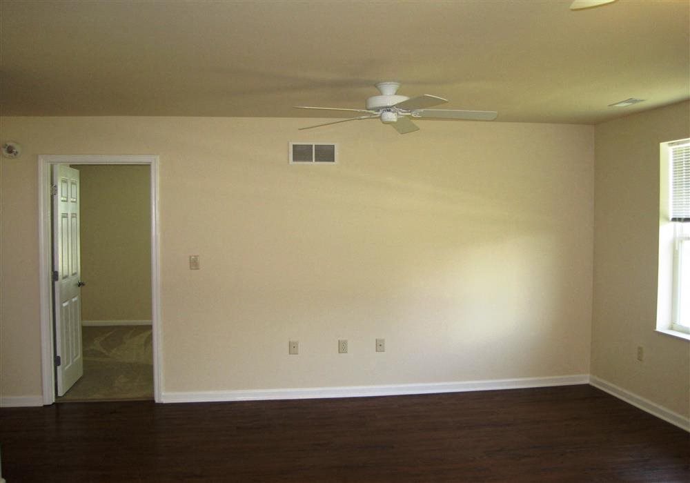 Bedroom, wood floors, large window and blinds