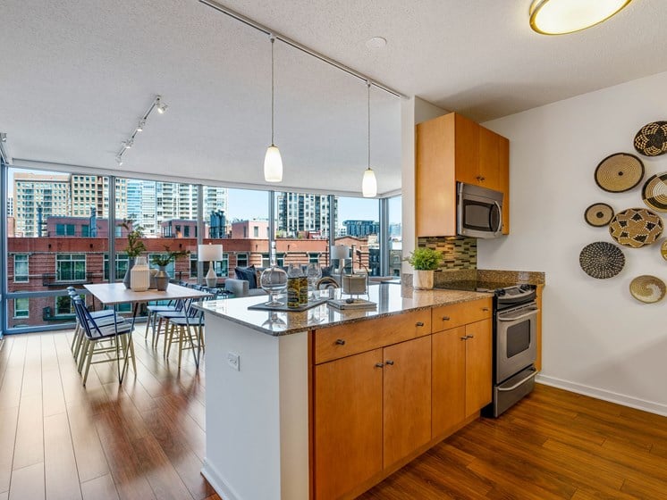 Kitchen photo with stainless steel appliances, wall decor, and a view of the living room
