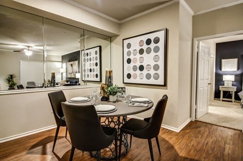 Cozy dining nook with hardwood style flooring, crown molding and wall mirror