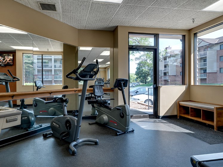 Fitness room with various equipment and a large mirror wall