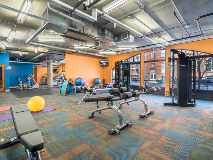Fitness room with orange and blue walls and lots of different equipment