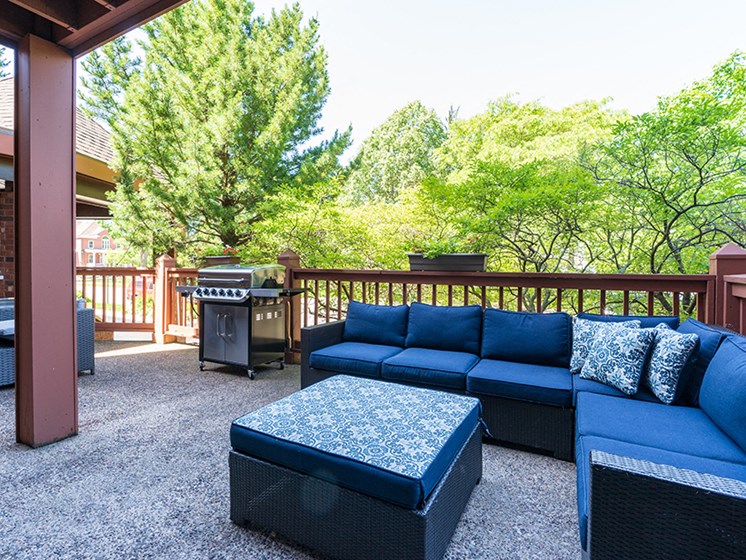Outdoor patio with blue chairs and a grill
